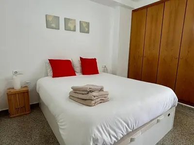 a bedroom with a white bed with red pillows at District Key - Valencia, Playa Patacona in Valencia