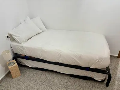 a bed with white sheets and pillows in a room at District Key - Valencia, Playa Patacona in Valencia