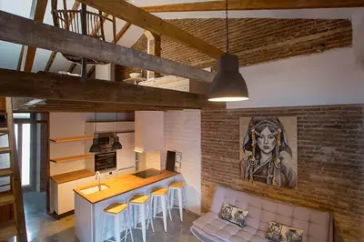 a kitchen and living room with a brick wall at Cozy loft style apartment in El Cabanyal in Valencia