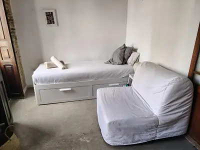 a small bedroom with a bed and a chair at Cozy loft style apartment in El Cabanyal in Valencia