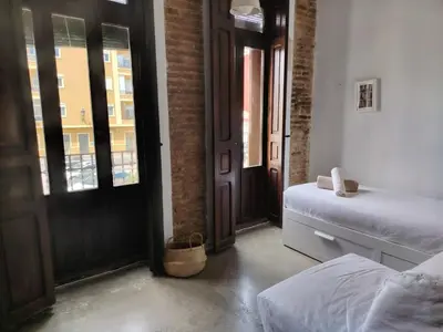 a bedroom with two beds and a door with windows at Cozy loft style apartment in El Cabanyal in Valencia