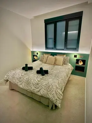 a bedroom with a large bed with two black pillows at Luxury apartment in Cabanyal in Valencia