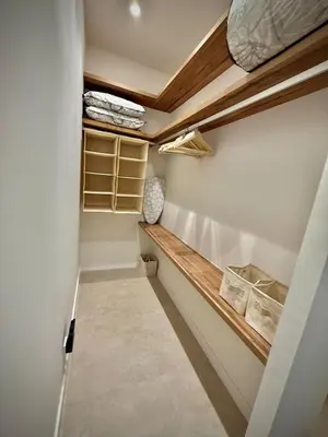 a walk in closet with a bench and shelves at Luxury apartment in Cabanyal in Valencia