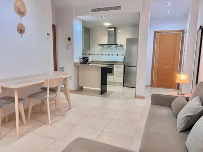 a kitchen and living room with a table and a couch at Apartamento Mare Nostrum in Valencia