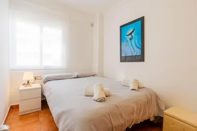 a bedroom with a bed with towels on it at Dictrict Key - Pobla de Farnals, Carabelas in Puebla de Farnals