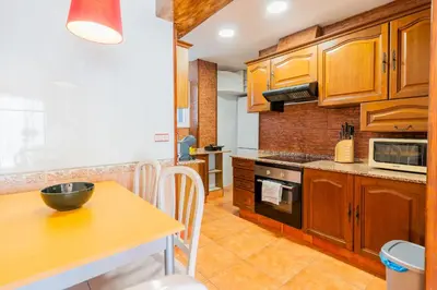 a kitchen with wooden cabinets and a wooden table at Dictrict Key - Pobla de Farnals, Carabelas in Puebla de Farnals