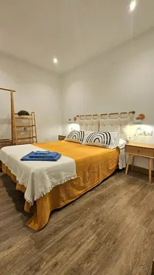 a bedroom with a large bed and a desk at La Casita de Camelia in Valencia