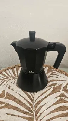 a black tea kettle sitting on top of a blanket at La Casita de Camelia in Valencia