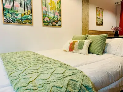 a bedroom with a bed with a green and white comforter at ORI A Cool & wide apartment next to historic center in Valencia