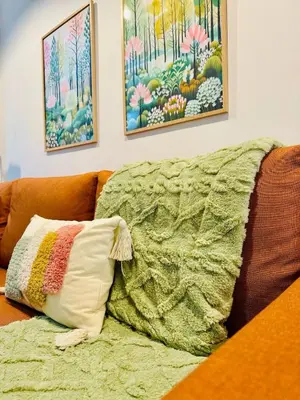 a pillow sitting on a couch with a blanket at ORI A Cool & wide apartment next to historic center in Valencia