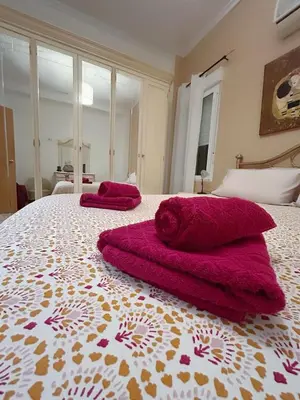 a bedroom with two red towels on a bed at El Almazán in Buñol