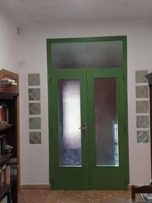 a green door with a window in a room at El Almazán in Buñol