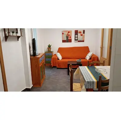 a living room with an orange couch and a table at El Almazán in Buñol
