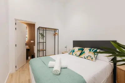 a bedroom with a white bed with a plant on it at Design loft in Valencia in Valencia