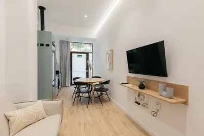 a living room with a table and a tv on a wall at Design loft in Valencia in Valencia