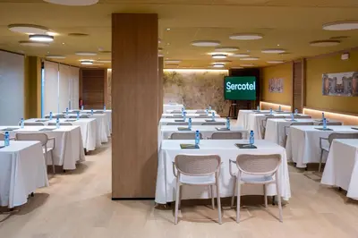 a conference room with tables and chairs and a screen at Hotel Sercotel Plana Onda in Onda