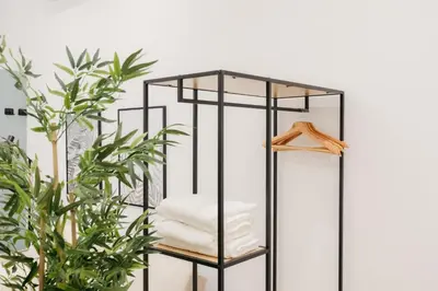 a black iron shelf with towels on it next to a plant at Elegant Loft in Valencia in Valencia