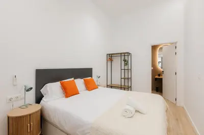 a bedroom with a large white bed with orange pillows at Elegant Loft in Valencia in Valencia