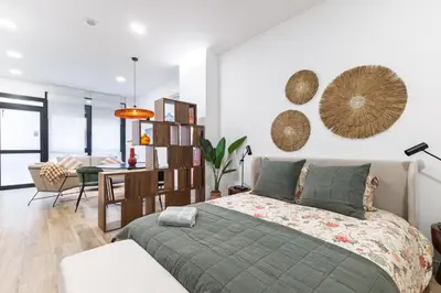 a bedroom with a bed and a dining room at Moderno loft reformado, Smart TV, AC, Beach, 3Pax in Valencia