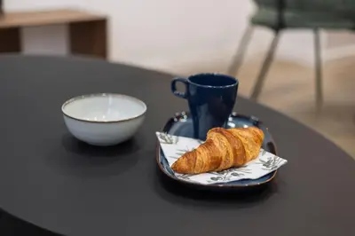 a plate with a croissant and a cup on a table at Moderno loft reformado, Smart TV, AC, Beach, 3Pax in Valencia