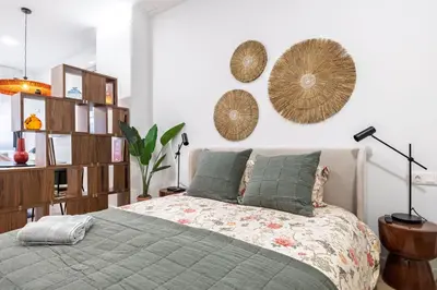a bedroom with a bed and a wall with mirrors at Moderno loft reformado, Smart TV, AC, Beach, 3Pax in Valencia