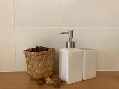 a white soap dispenser next to a basket of chocolate at El Apartamento in Valencia