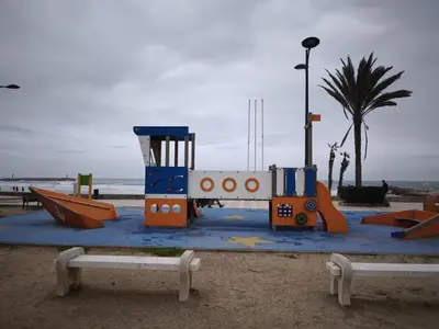 a playground on the beach with a chair and slides at Apartment with views of the Mediterranean- Little Venice in Port Saplaya