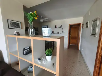 a room with a shelf with a vase of flowers at Apartment with views of the Mediterranean- Little Venice in Port Saplaya