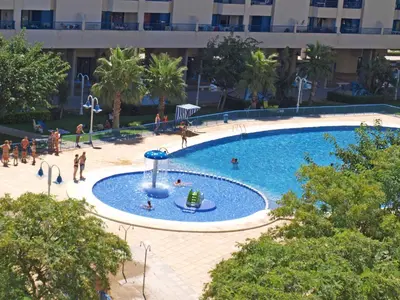 a large swimming pool with people playing in it at ApartUP Patacona Iconic I in Valencia