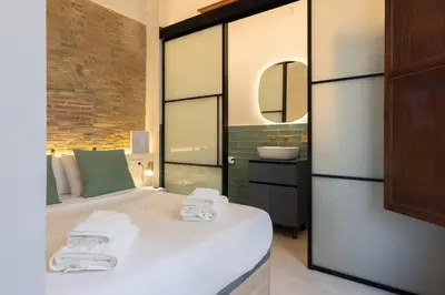 a bedroom with a bed with a sink and a mirror at Apartamento 4 Pax Vistas Torres de Serrano in Valencia