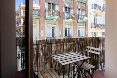 a balcony with a wooden bench and a building at Apartamento 4 Pax Vistas Torres de Serrano in Valencia