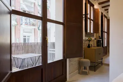a hallway with a door and a table and a chair at Apartamento 4 Pax Vistas Torres de Serrano in Valencia