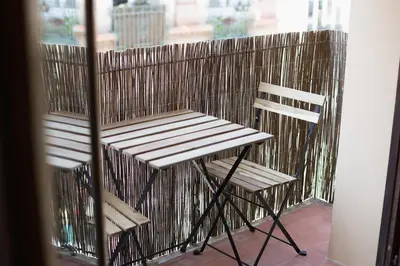 a wooden chair sitting on top of a balcony at Apartamento 4 Pax Vistas Torres de Serrano in Valencia