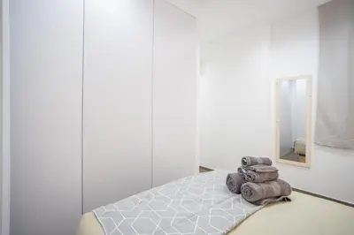 a room with a bed with a mirror and towels at Valencia Central Flats-Elegante, junto al Roig Arena in Valencia
