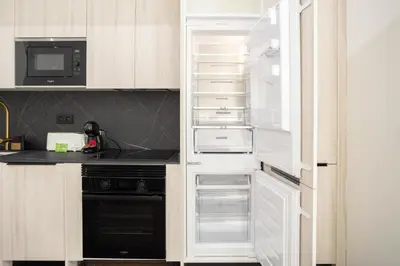 a kitchen with white cabinets and an empty refrigerator at Valencia Central Flats-Elegante, junto al Roig Arena in Valencia