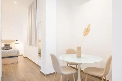 a white dining room with a table and chairs at Valencia Central Flats-Moderno, junto al Roig Arena in Valencia
