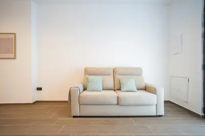 a white chair with two blue pillows in a room at Valencia Central Flats-Moderno, junto al Roig Arena in Valencia