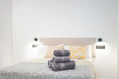 a pile of towels sitting on top of a bed at Valencia Central Flats-Moderno, junto al Roig Arena in Valencia