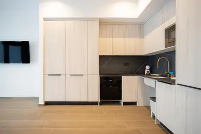 a kitchen with wooden cabinets and a black appliance at Valencia Central Flats-Moderno, junto al Roig Arena in Valencia