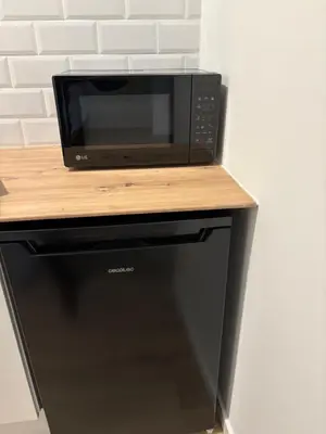 a microwave sitting on top of a black refrigerator at Valencia City Scapes in Valencia