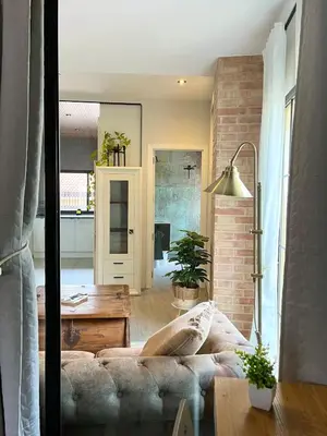 a living room with a couch and a brick wall at Apartamento boutique luminoso a 5 min del metro in Bétera