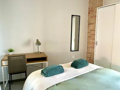 a bedroom with a desk and a bed with two pillows at Apartamento boutique luminoso a 5 min del metro in Bétera
