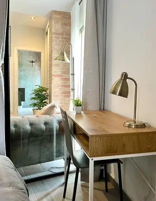 a dining room table with a lamp and a couch at Apartamento boutique luminoso a 5 min del metro in Bétera