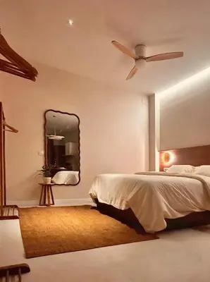 a bedroom with a bed with a ceiling fan and a mirror at Pivote Flats-Playa B in Valencia