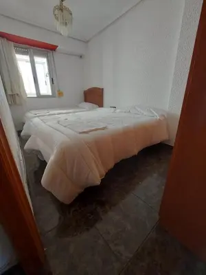 a bedroom with two beds and a window at Reina Beach House in Valencia