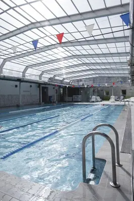 a large indoor swimming pool with a ceiling at Fitness & Spa, Suite Atalanta Valencia in Valencia