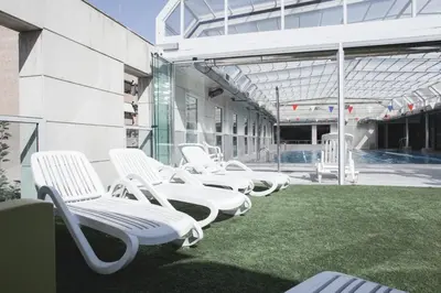 a row of white chairs sitting outside of a building at Fitness & Spa, Suite Atalanta Valencia in Valencia