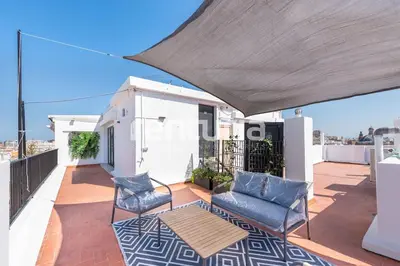 a balcony with chairs and a table on a roof at Carme Sky in Valencia