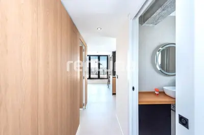 a corridor of a bathroom with a sink and a mirror at Carme Sky in Valencia