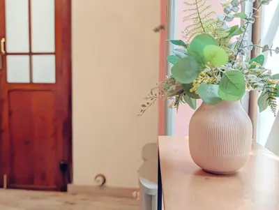 a vase with a plant in it sitting on a table at Portrait Boutique Villa in Valencia